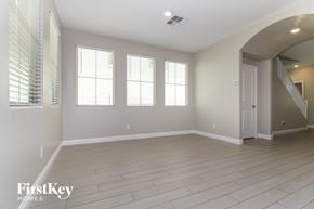 Goodyear house for rent - A spacious room with wooden flooring and a staircase on the right.