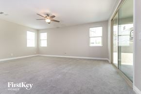 Goodyear house for rent - A spacious room with a ceiling fan and two windows.