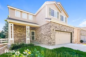 Aurora house for rent - A house with a stone wall and a garage door.