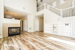 Aurora house for rent - A spacious living room with a fireplace and wooden flooring.