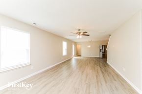 Winston Salem house for rent - an empty living room with wood floors and a ceiling fan