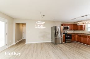 Winston Salem house for rent - a kitchen and living room with wood flooring and a stainless steel refrigerator