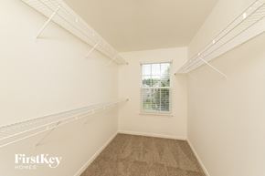 Winston Salem house for rent - a spacious closet with shelves and a window in a white room