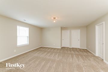 Winston Salem house for rent - a spacious living room with carpet and two doors