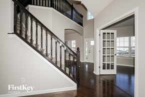 Avon house for rent - A staircase with a black railing and wooden steps leading to a white door.