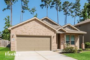Conroe house for rent - A house with a garage and a driveway in front of it.
