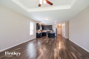 Conroe house for rent - A spacious room with wooden floors and a ceiling fan.