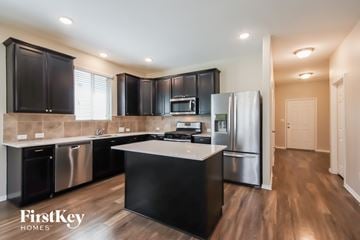 Conroe house for rent - A modern kitchen with black cabinets and stainless steel appliances.