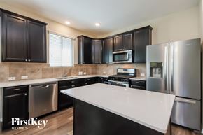 Conroe house for rent - A modern kitchen with stainless steel appliances and black cabinets.