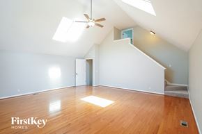 Nashville house for rent - an empty living room with wood floors and a ceiling fan