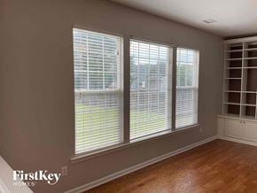 Charlotte house for rent - a living room with three windows and a wood floor