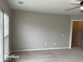 Charlotte house for rent - an empty living room with a ceiling fan and a window