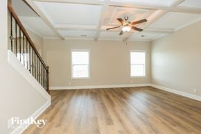 Clarksville house for rent - an empty living room with hardwood floors and a ceiling fan