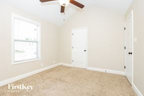 Clarksville house for rent - a bedroom with a ceiling fan and a white door