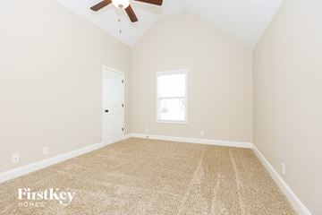 Clarksville house for rent - the spacious living room with carpet and a ceiling fan