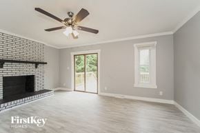 Charlotte house for rent - A spacious room with a fireplace and a ceiling fan.