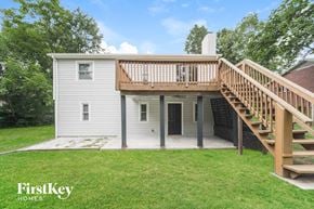 Charlotte house for rent - A house with a wooden deck and stairs leading to the entrance.