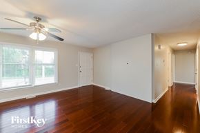 Archdale house for rent - A room with wooden floors and a ceiling fan.