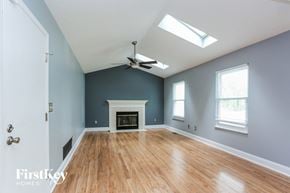 Grove City house for rent - A spacious room with a fireplace and a ceiling fan.