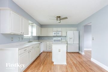Grove City house for rent - A kitchen with white cabinets and a white fridge.