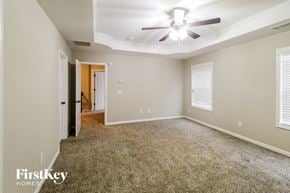 Jefferson house for rent - A spacious room with a ceiling fan and carpeted floor.