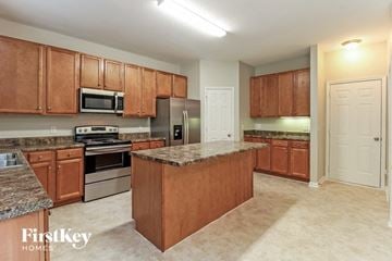 Greensboro house for rent - a kitchen with wooden cabinets and stainless steel appliances