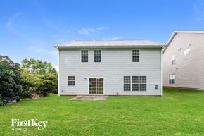 Greensboro house for rent - the back of a white house with a grassy yard and a white barn