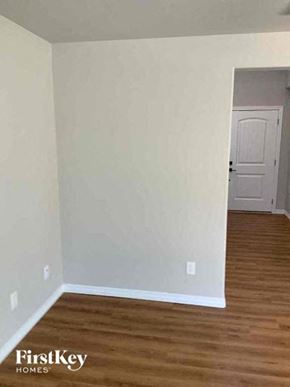 Colorado Springs house for rent - an empty room with a wooden floor and a white door