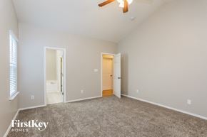 Raleigh house for rent - A spacious room with a carpeted floor and a ceiling fan.