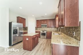 Charlotte house for rent - a kitchen with wooden cabinets and stainless steel appliances