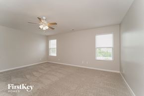 Charlotte house for rent - a bedroom with a ceiling fan and a carpeted floor