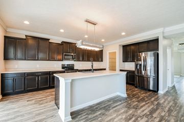 Fortville house for rent - a kitchen with a large island and dark wood cabinets