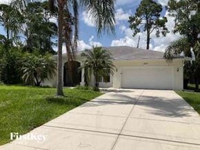 North Port house for rent - a white house with a garage and palm trees