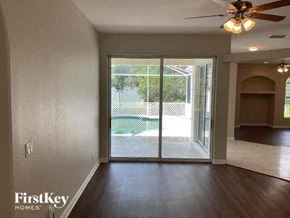 North Port house for rent - an empty living room with a sliding glass door to a pool