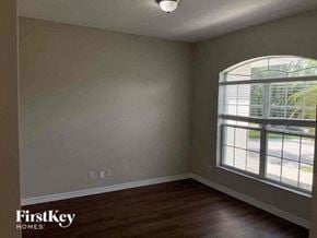 North Port house for rent - an empty bedroom with a large window and wooden floors