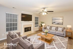 Harrisburg house for rent - A living room with a grey couch, a coffee table, a fireplace, and a television.