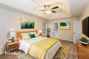 Harrisburg house for rent - A bedroom with a bed, a ceiling fan, and a painting on the wall.