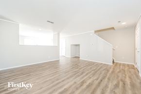 Morrison house for rent - the living room and dining room of an apartment with white walls and wood flooring