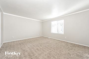 Morrison house for rent - a spacious living room with carpet and a window