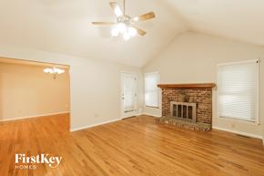 Kansas City house for rent - a living room with a brick fireplace and wooden floors