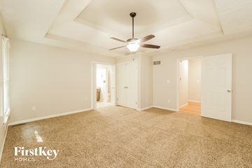 Kansas City house for rent - a living room with carpet and a ceiling fan