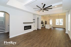 Cordova house for rent - A spacious living room with a fireplace and a ceiling fan.