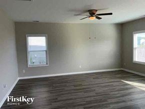 Summerville house for rent - an empty living room with a ceiling fan and wood floors