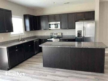 Summerville house for rent - a kitchen with stainless steel appliances and black cabinets