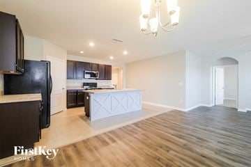 Davenport house for rent - A kitchen with a black fridge and a wooden floor.
