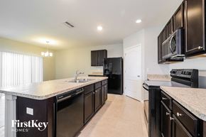 Davenport house for rent - A kitchen with black appliances and a FirstKey Homes logo.