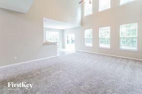 Summerville house for rent - the living room and dining room of an empty home with white walls and carpet