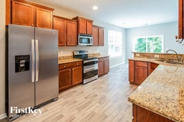 Summerville house for rent - a kitchen with stainless steel appliances and wooden cabinets