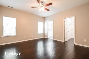 Holly Springs house for rent - A spacious room with a ceiling fan and wooden flooring.