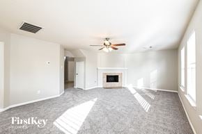 Tomball house for rent - A spacious living room with a fireplace and a ceiling fan.